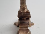 a gold candle holder with a stack of books on top of it