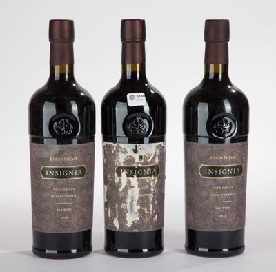 trois bouteilles de vin posées les unes à côté des autres sur une surface blanche