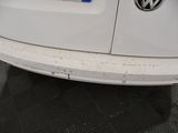 the rear end of a white van with a blue sticker on it ' s bumper
