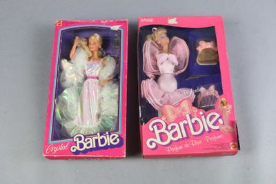 two barbie dolls are sitting in a pink box on a table