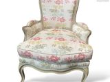 a white chair with a floral upholstered back