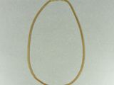 un collier en or avec une chaîne sur fond blanc