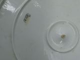 underside view of a white porcelain bowl with a hole in the center