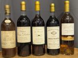several bottles of wine are lined up on a wooden tray