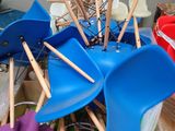 many different colored plastic chairs and umbrellas in a container
