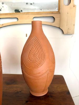 deux vases posés sur une table en bois devant un miroir