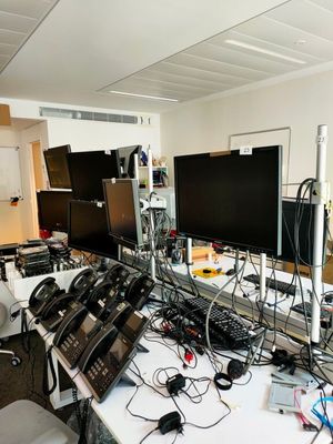 il y a beaucoup d'appareils électroniques sur la table dans la pièce