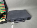 a black case with a pen in it sitting next to a green and red case