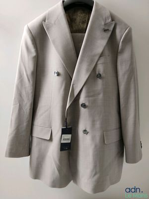 the jacket is hanging on a hanger on the wall