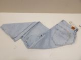 denim pants on a white table with a tag on it