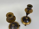 three antique brass candlesticks on a white background