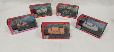 quatre boîtes contenant des petites voitures, posées sur une surface blanche