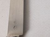 a knife that is sitting on a table next to a wall