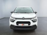 the front view of a white citrole parked in a white room