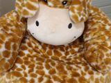 a stuffed giraffe that is sitting on a chair