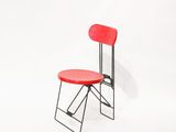 une chaise rouge posée sur une surface blanche