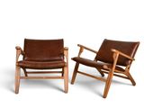 two brown leather lounge chairs with wooden arms and arms