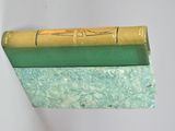 a green book sitting on top of a green marble block