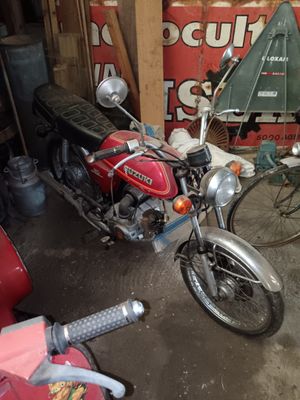 a red motorcycle parked in a garage next to a red motorcycle