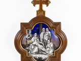 a wooden cross with a picture of jesus laying on the ground