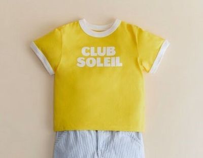 un t-shirt jaune et un short bleu sur un cintre