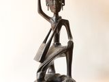 statue d'une femme tenant un bol sur la tête
