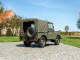 a green military vehicle parked on a cobblestone road