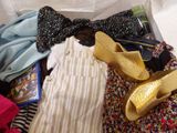 a pile of clothes and a pair of shoes on a bed