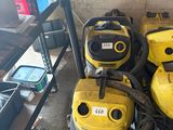 several yellow vacuum cleaners are lined up in a room