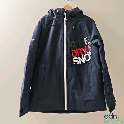 une veste bleu marine ornée d'un logo rouge et blanc, suspendue à un cintre