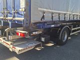 a truck with a tarp on the back parked in a parking lot