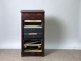 a small wooden cabinet with a lot of files on it