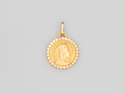 une pièce d'or sur laquelle figure, au centre, le visage d'une femme