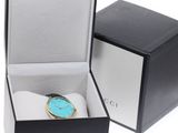 a black box with a watch inside of it on a white surface