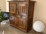 a wooden cabinet in the middle of a living room