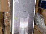 packaging of a box with a light inside of it sitting on a pile of boxes