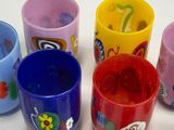 many different colored cups sitting on a table