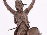 bronze statue of a soldier holding a drum and a drum stick
