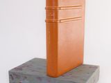an orange book sitting on top of a wooden block