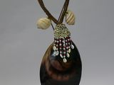 a vase with a long neck and a beaded decoration on it