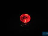 une boule rouge posée sur une surface noire dans l'obscurité