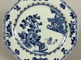 blue and white plate with a design of animals and flowers on it