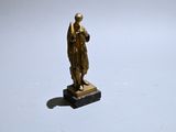 a small statue of a man standing on a marble base