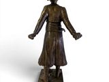 bronze statue of a woman standing on a pedestal with her hands out