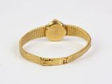 a close up of a gold bracelet with a round clasp