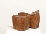 pair of wooden stools sitting on top of a white pedestal