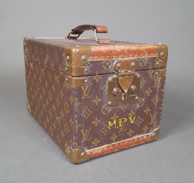 a brown and tan suitcase sitting on a grey surface