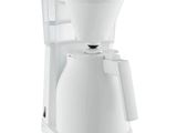 une cafetière blanche posée sur un plan de travail blanc