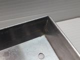 a metal tray with holes in it sitting on a table