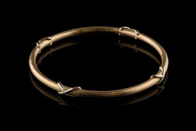 a close up of a gold bracelet on a black background